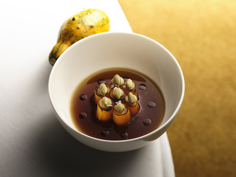 l’amuse bouche di Eugenio Boer, proposta in un solo elemento composto da ogni singola sua parte: rotolini di zucca in criocottura, consommè di bucce di zucca, olio di semi di zucca e semi di zucca tostati